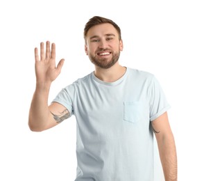 Photo of Happy young man waving to say hello on white background