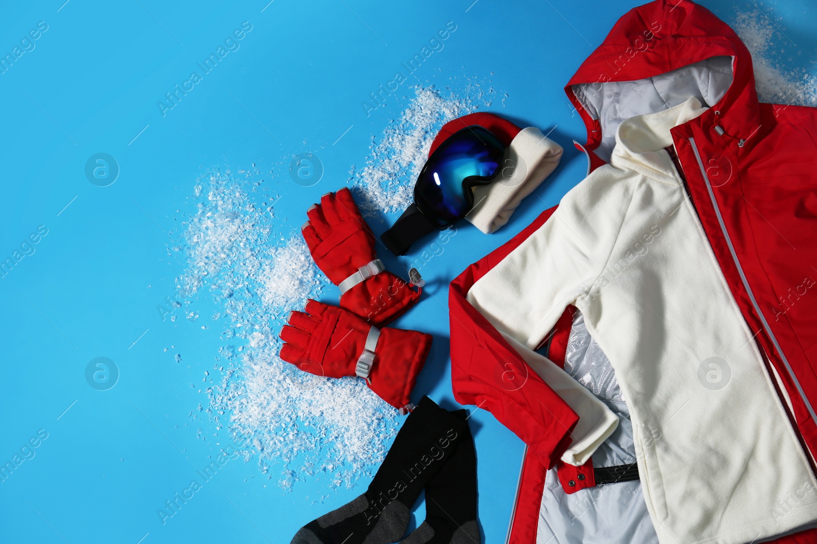 Photo of Stylish winter sport clothes on light blue background, flat lay