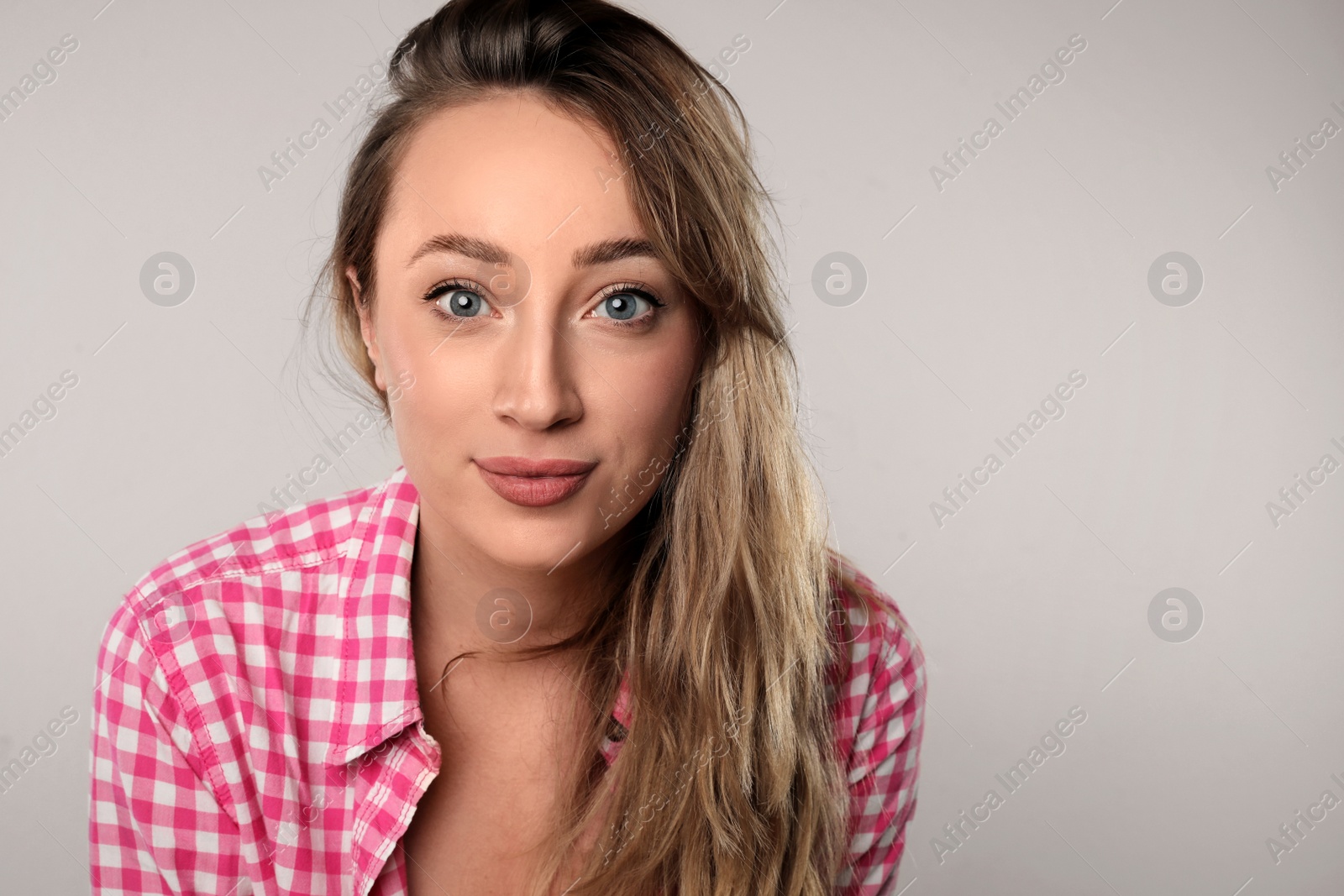 Photo of Portrait of young beautiful woman on grey background