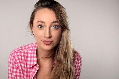 Photo of Portrait of young beautiful woman on grey background