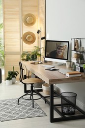 Photo of Comfortable workplace with computer in light room. Interior design