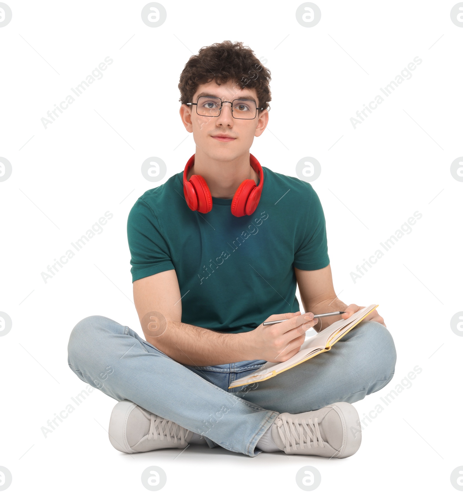 Photo of Portrait of student with notebook and headphones sitting on white background