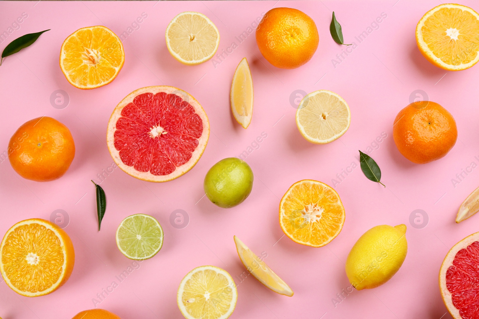 Photo of Flat lay composition with tangerines and different citrus fruits on pink background