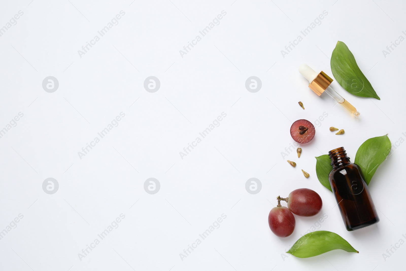 Photo of Composition with natural grape seed oil on white background, top view. Organic cosmetic