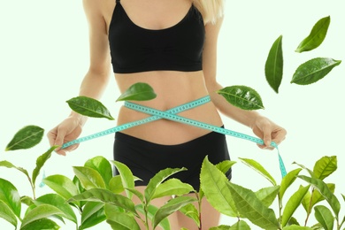 Image of Young woman measuring her waist on light background, closeup. Tea leaves for slimming drink