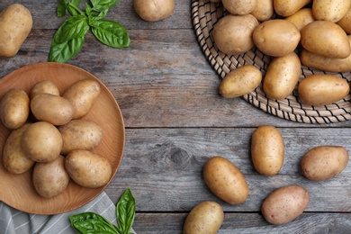 Photo of Flat lay composition with fresh ripe organic potatoes on wooden background