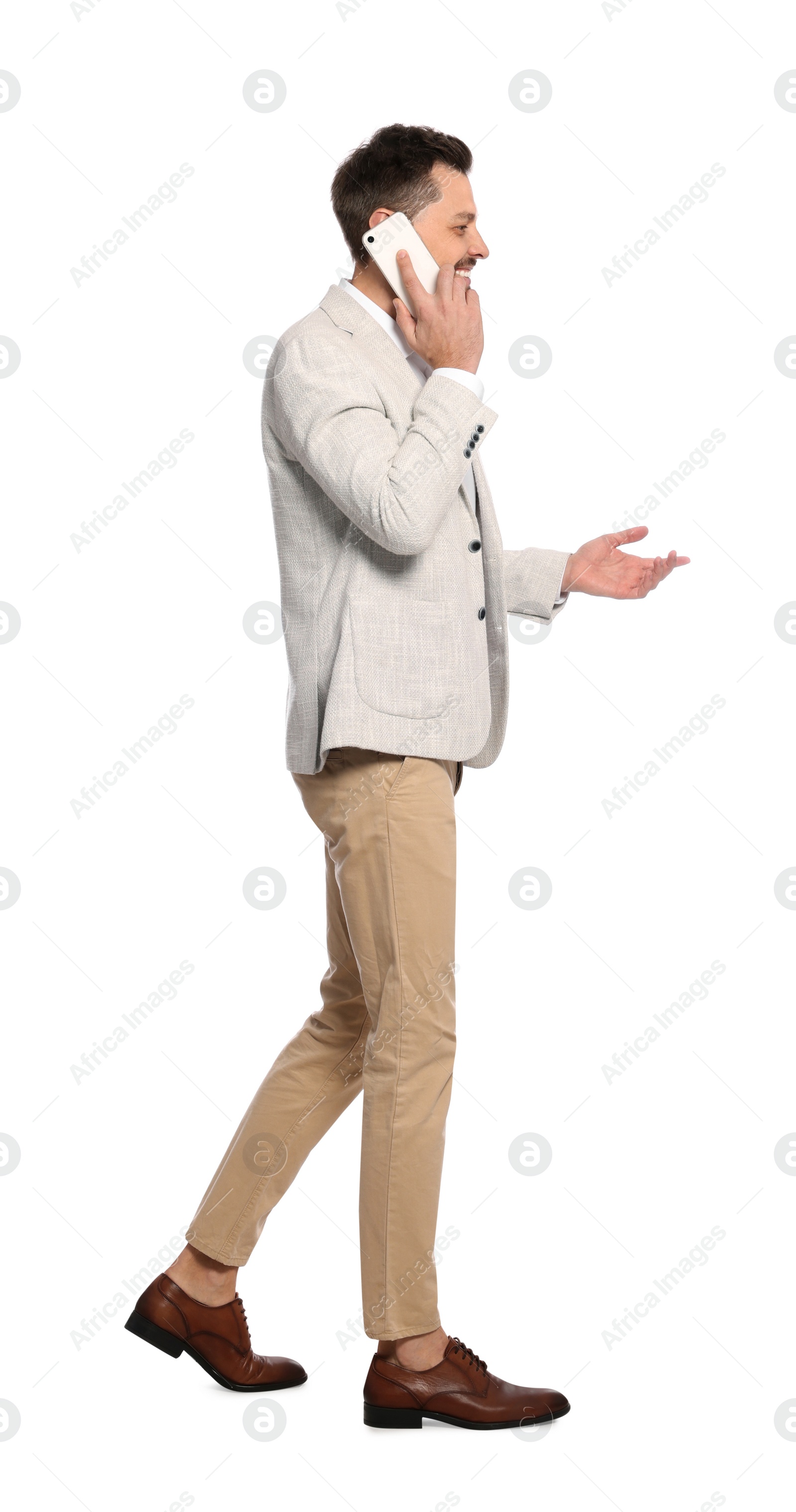 Photo of Man talking on phone while walking against white background