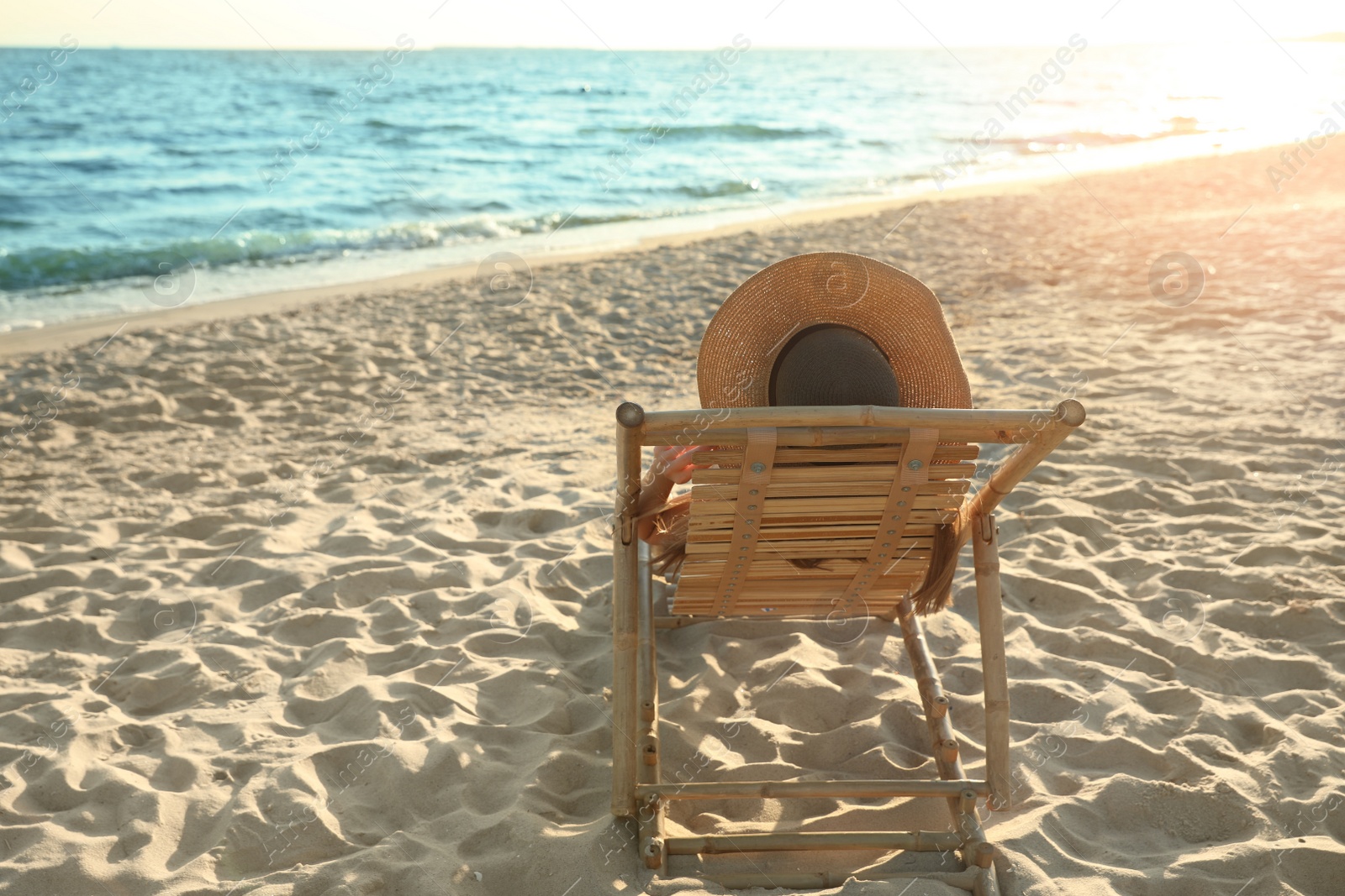 Photo of Young woman relaxing in deck chair on beach