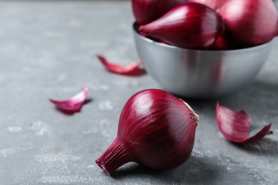 Photo of Tasty ripe red onions on grey table