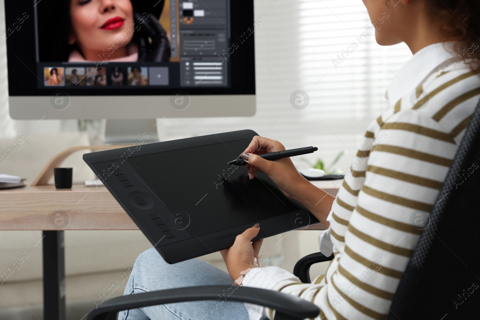 Photo of Professional retoucher working with graphic tablet at desk in office, closeup