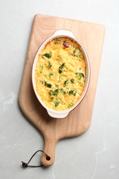 Photo of Tasty broccoli casserole on grey marble table, top view