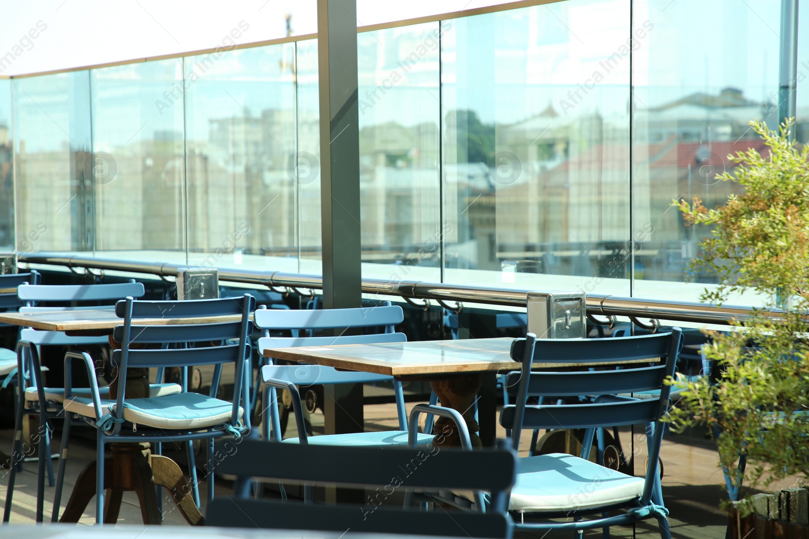 Photo of Observation area cafe. Tables, chairs and plant against beautiful cityscape