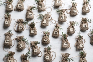 New Year advent calendar with gifts on white wooden background, flat lay