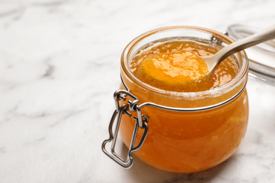 Homemade delicious orange jam on marble table