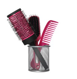 Hairbrushes and comb in holder on white background