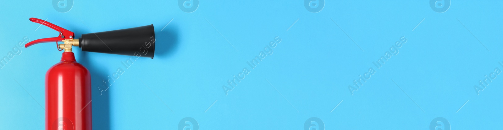 Image of Fire extinguisher on light blue background, top view with space for text. Banner design