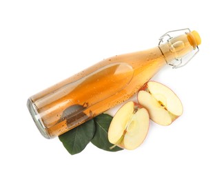 Photo of Glass bottle with delicious cider, pieces of ripe apple and leaves on white background, top view