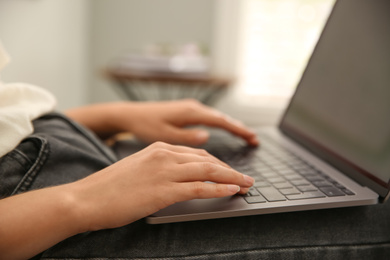 Photo of Woman working with modern laptop indoors, closeup