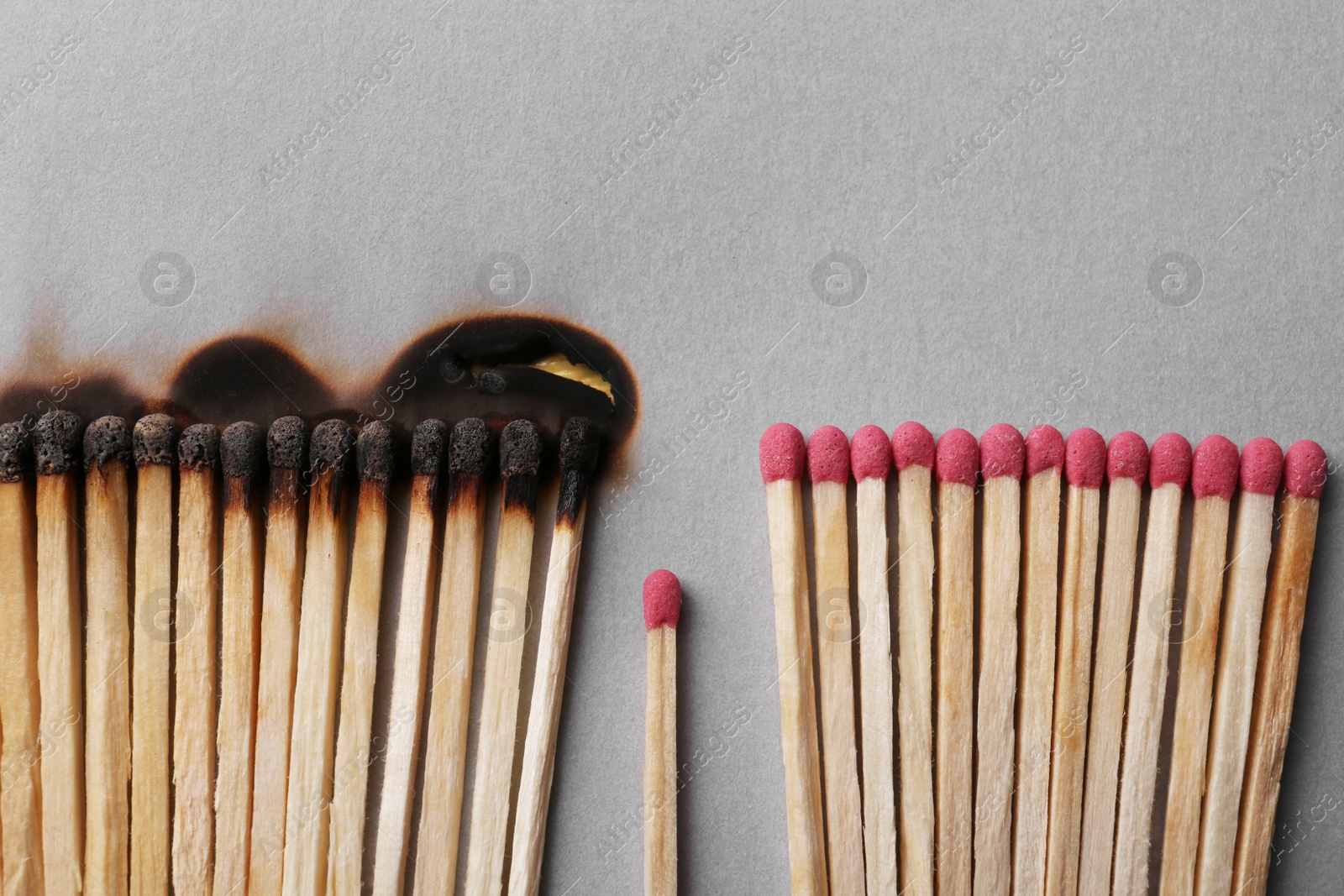 Photo of Burnt and whole matches on light grey background, flat lay