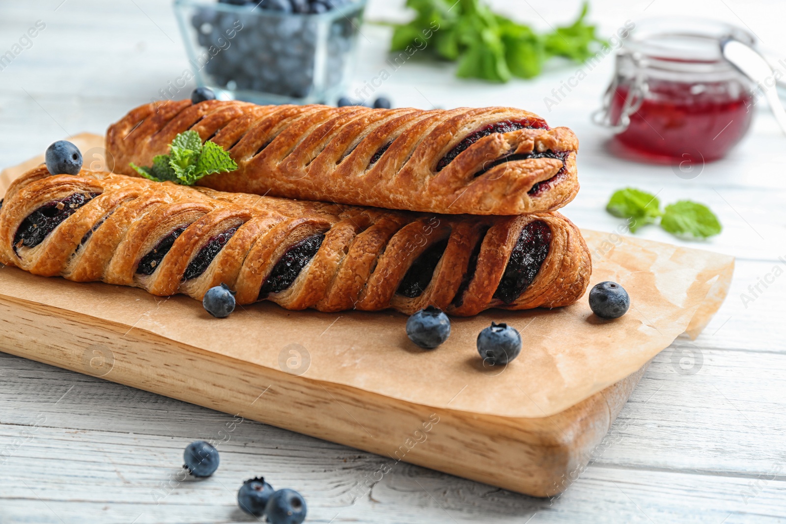 Photo of Fresh delicious puff pastry with sweet berries served on white wooden table