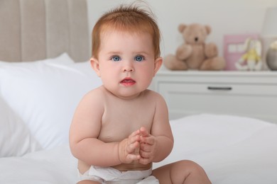Photo of Cute little redhead baby on bed at home