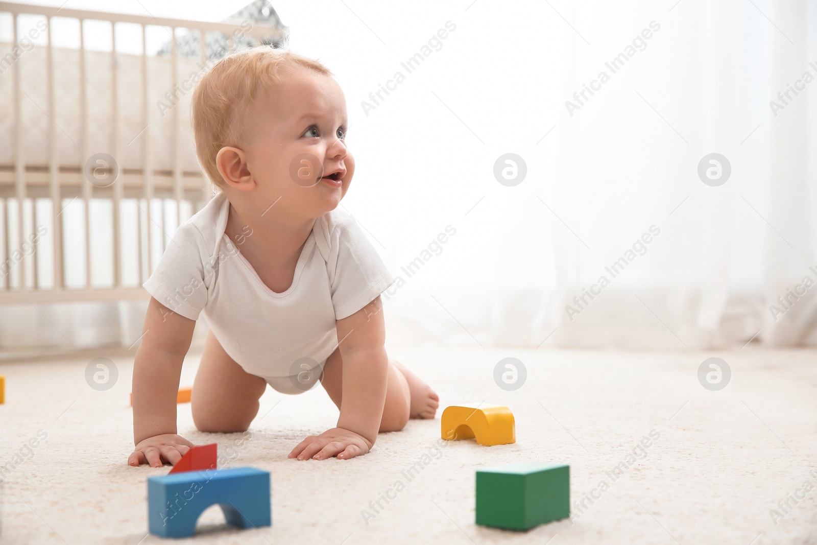 Photo of Cute little baby crawling on carpet indoors, space for text