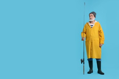 Photo of Fisherman with fishing rod on light blue background, space for text