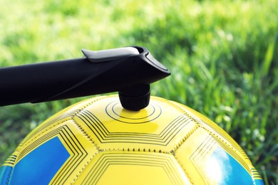 Photo of Inflating ball with manual pump outdoors, closeup