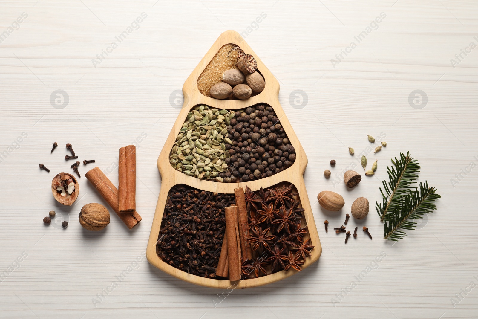 Photo of Different spices, nuts and fir branches on white wooden table, flat lay