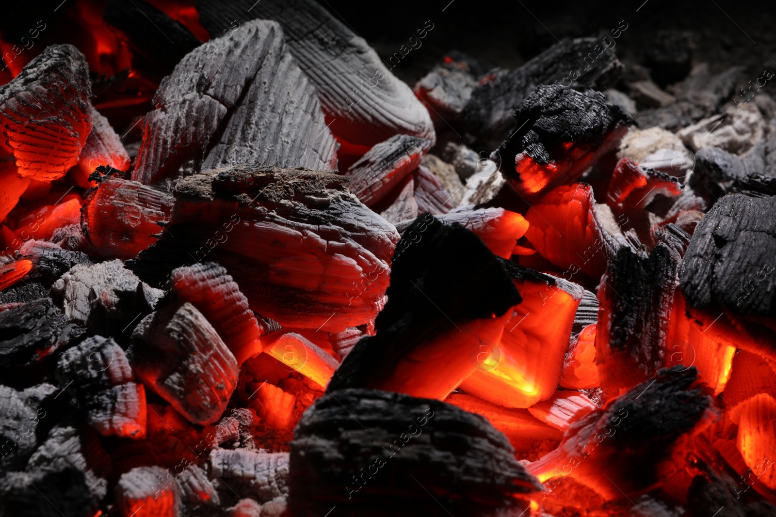 Photo of Pieces of hot smoldering coal as background, closeup