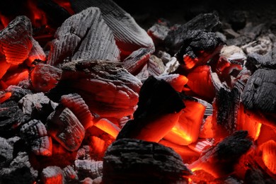 Photo of Pieces of hot smoldering coal as background, closeup