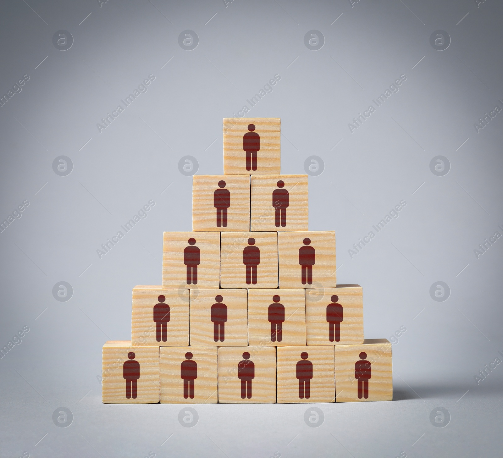 Image of Team and management concept. Pyramid of wooden cubes with human icons on grey background