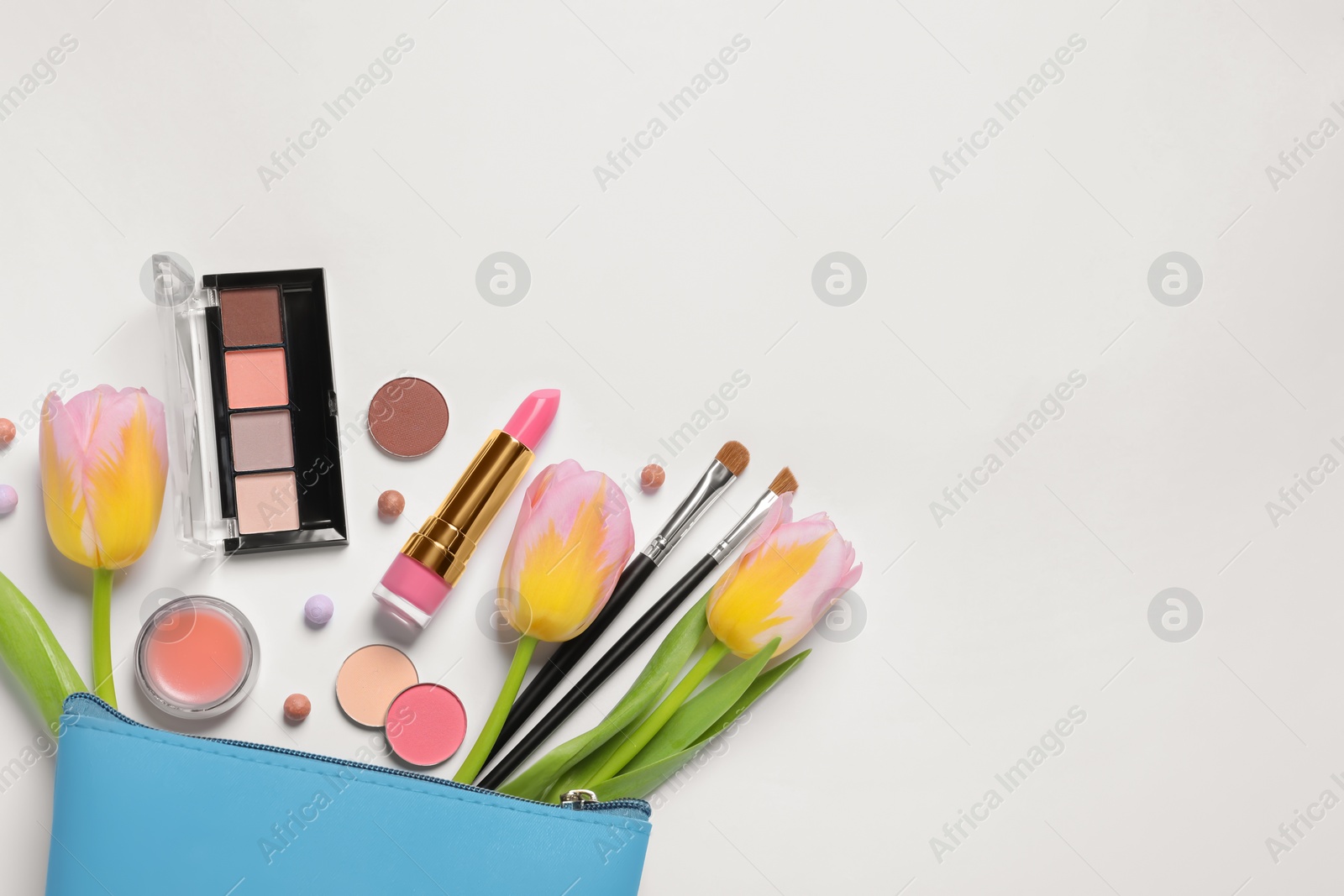 Photo of Flat lay composition with different makeup products and beautiful flowers on white background, space for text