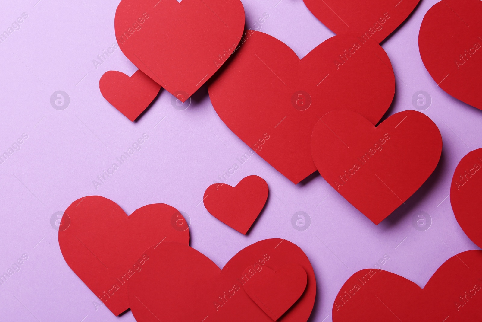 Photo of Red paper hearts on violet background, flat lay