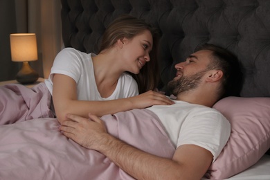 Photo of Young couple together in bed at nighttime