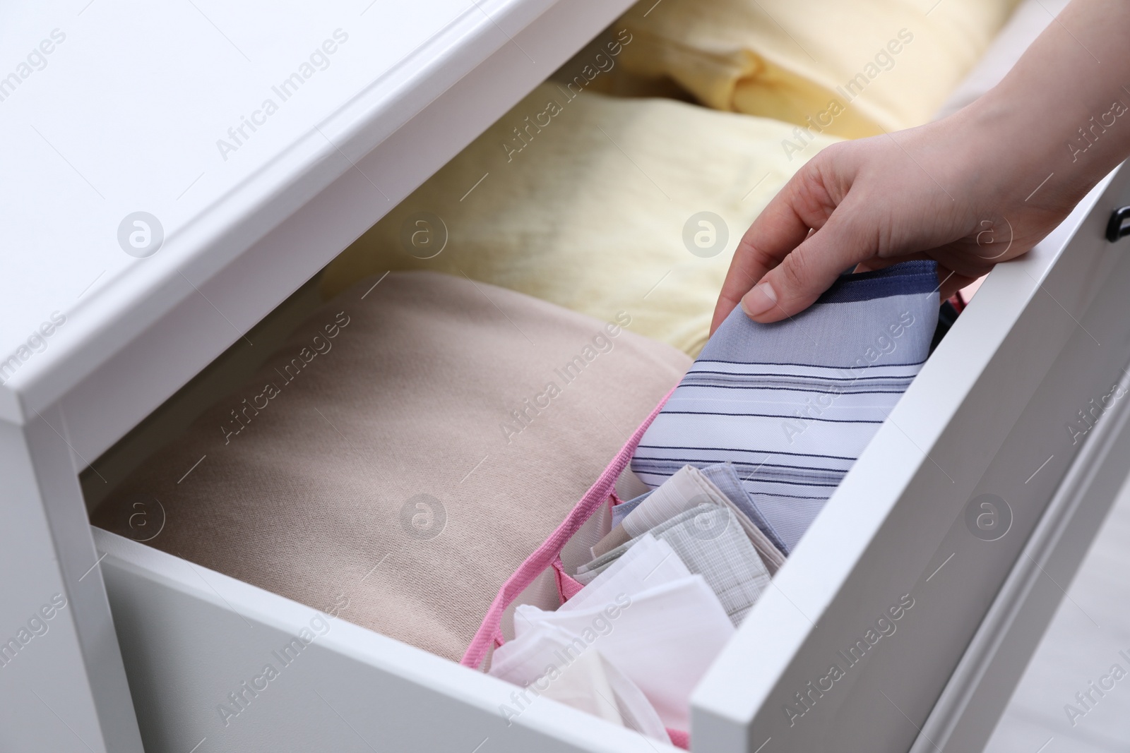 Photo of Woman taking handkerchief from drawer at home, closeup