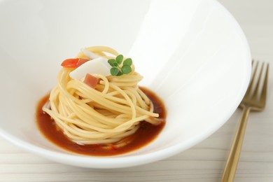 Photo of Tasty spaghetti with sauce served on white wooden table, closeup. Exquisite presentation of pasta dish