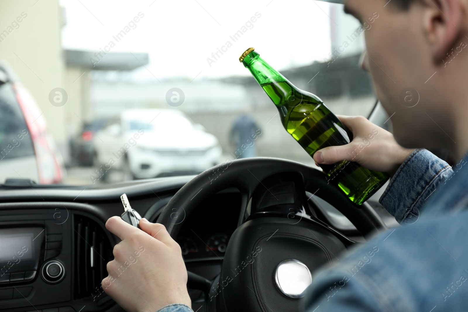 Photo of Man with bottle of beer driving car, closeup. Don't drink and drive concept