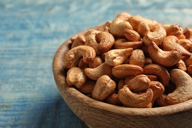 Tasty cashew nuts in bowl on table, closeup