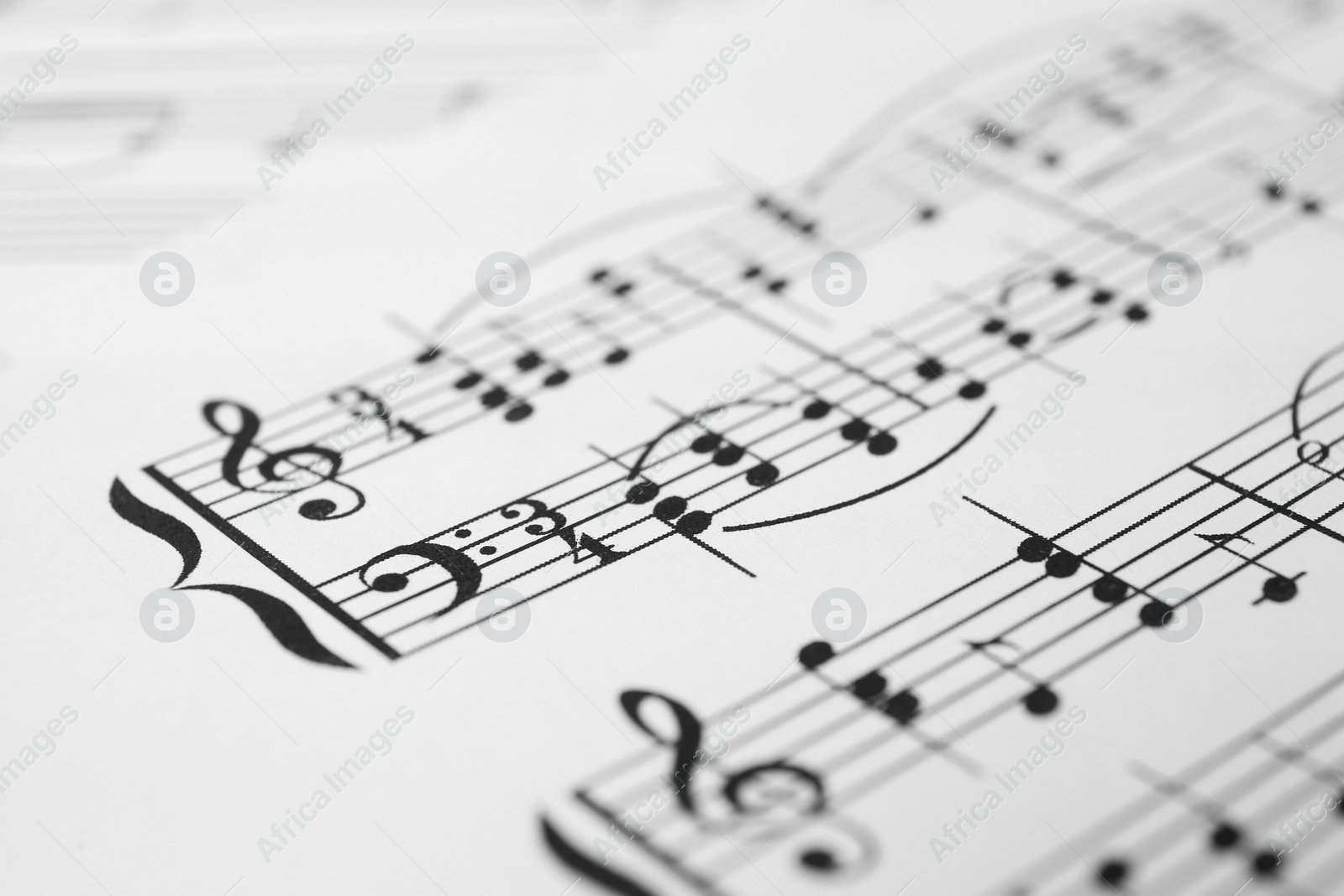 Photo of Sheet of paper with music notes as background, closeup view