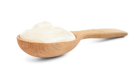 Wooden spoon with sour cream on white background