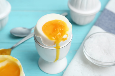 Photo of Soft boiled chicken egg served on light blue table