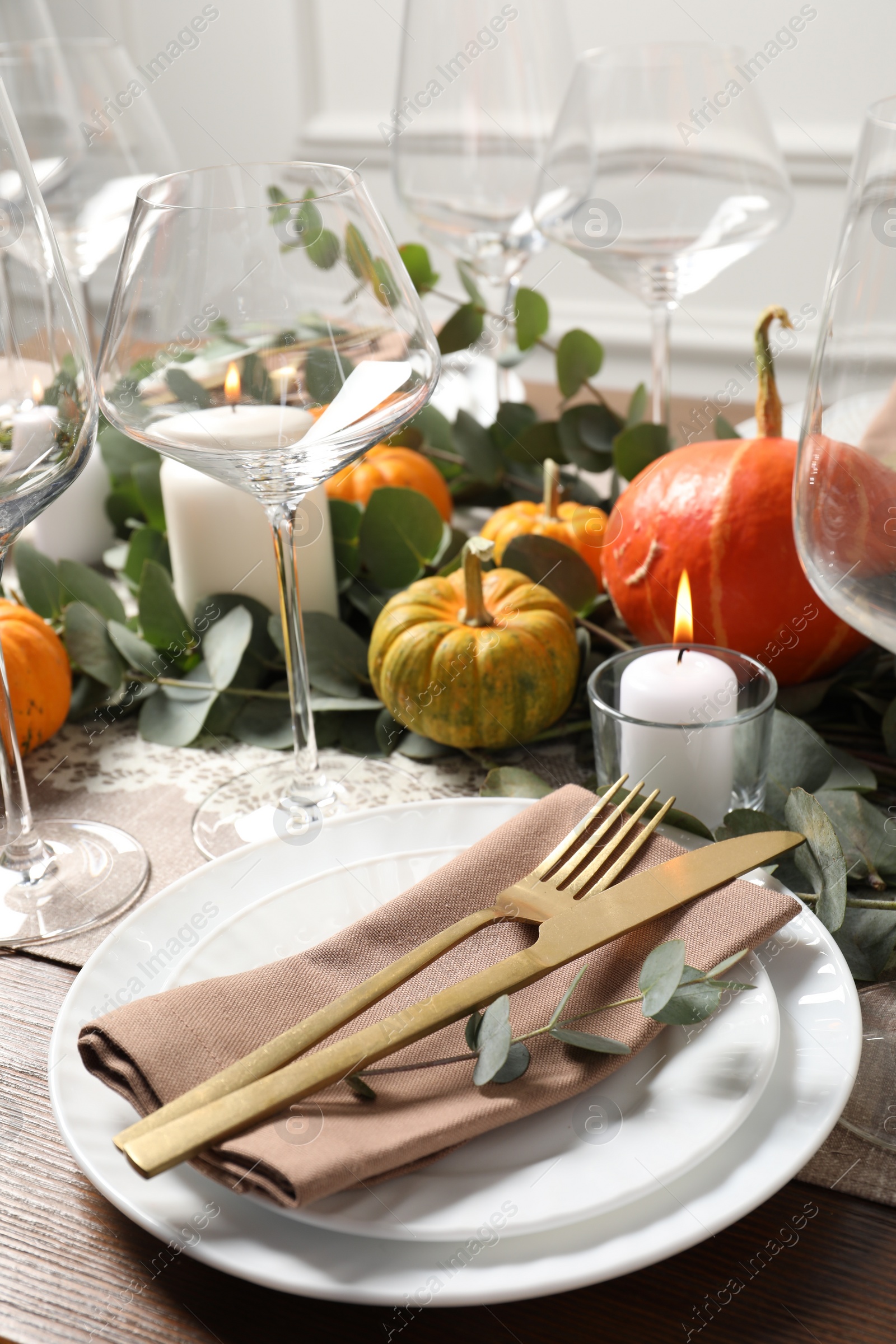 Photo of Beautiful autumn table setting. Plates, cutlery, glasses, pumpkins and floral decor