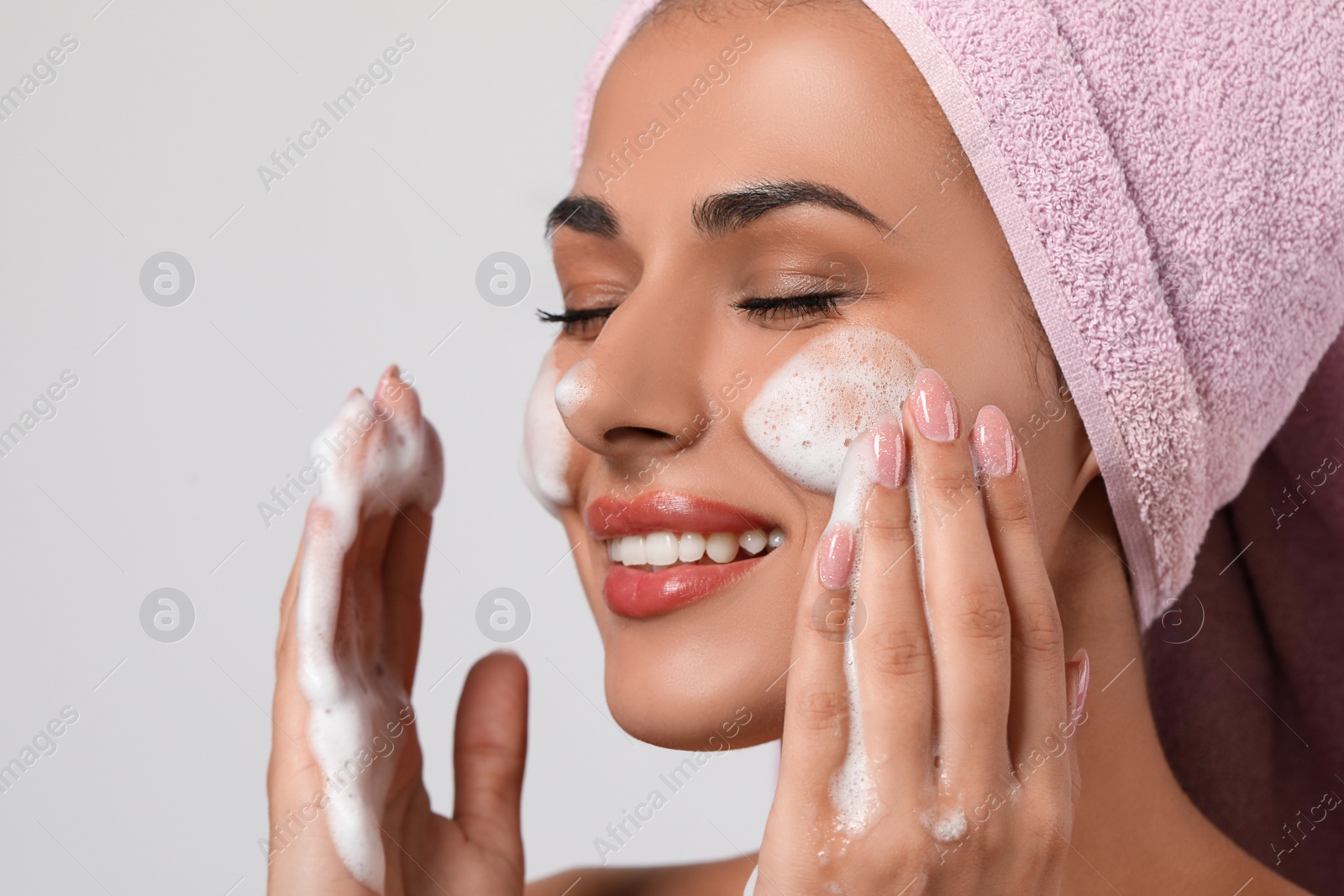 Photo of Beautiful woman applying facial cleansing foam on white background