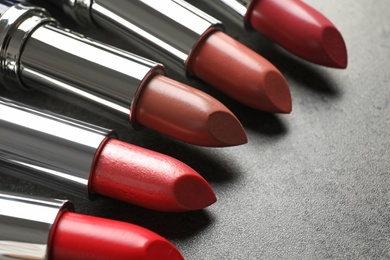 Photo of Set of different lipsticks on grey background, closeup