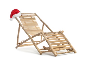 Photo of Wooden deck chair and Santa Claus hat on white background. Christmas vacation