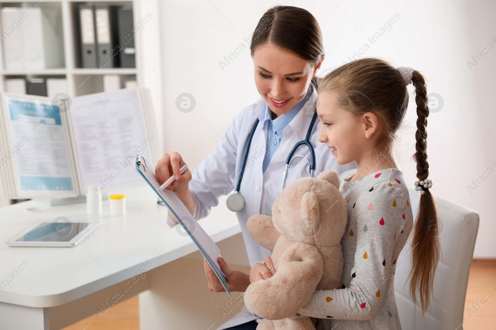 Photo of Children's doctor working with little patient in clinic