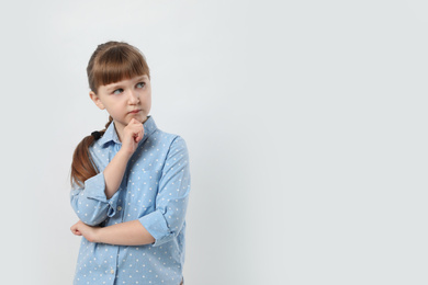 Photo of Pensive little girl on white background, space for text. Thinking about answer to question