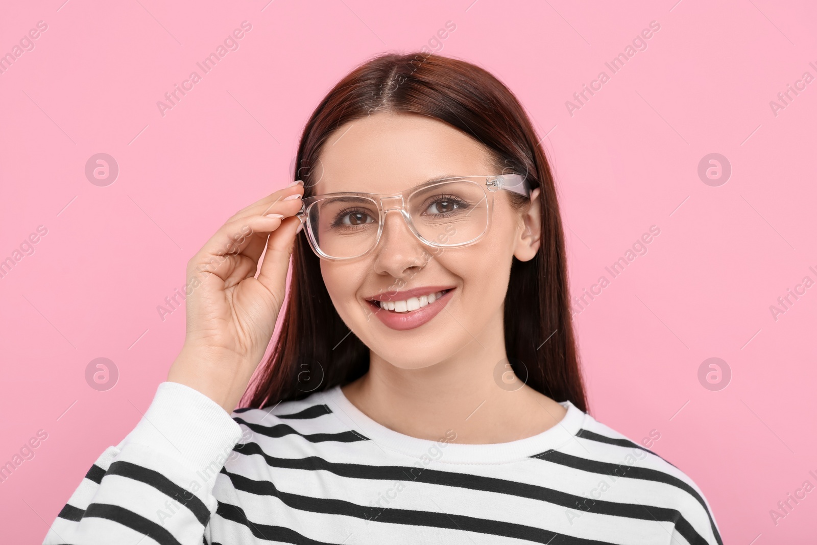 Photo of Portrait of smiling woman in stylish eyeglasses on pink background