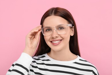 Photo of Portrait of smiling woman in stylish eyeglasses on pink background